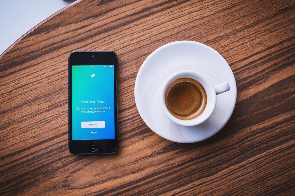 画像：コーヒーカップとTwitterを開いたスマートフォン