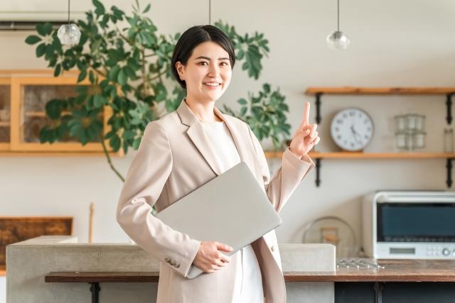 画像：ノートパソコンを持つおしゃれな女性