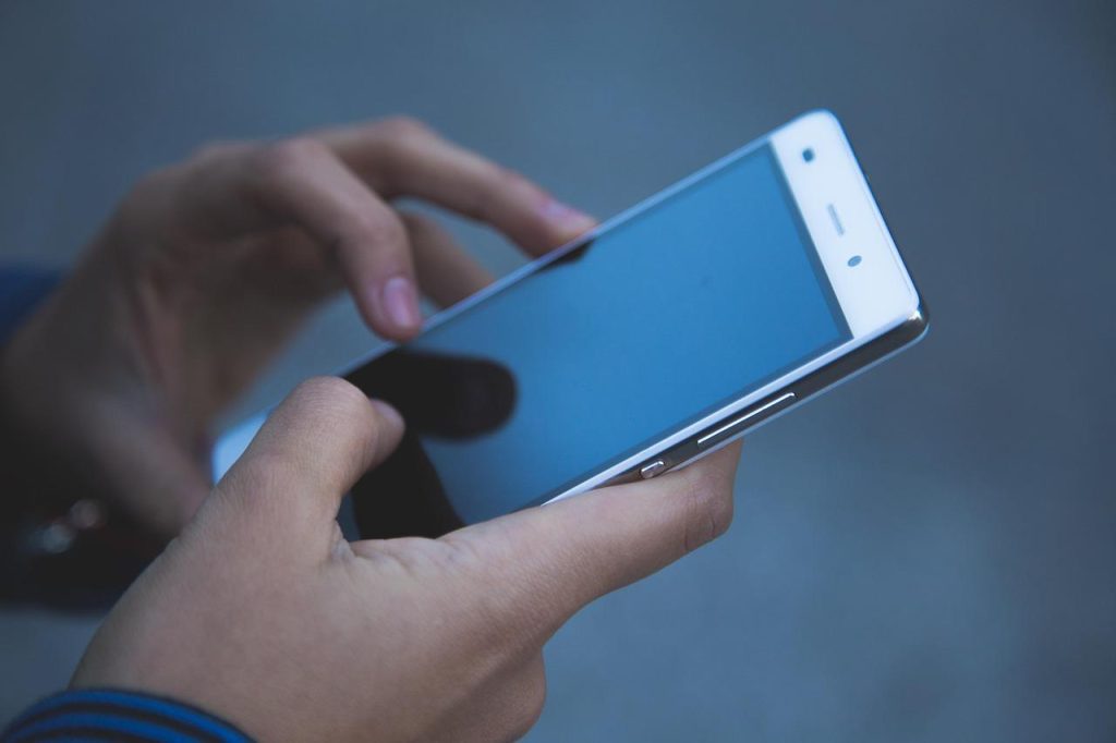 画像：スマートフォンを操作する手