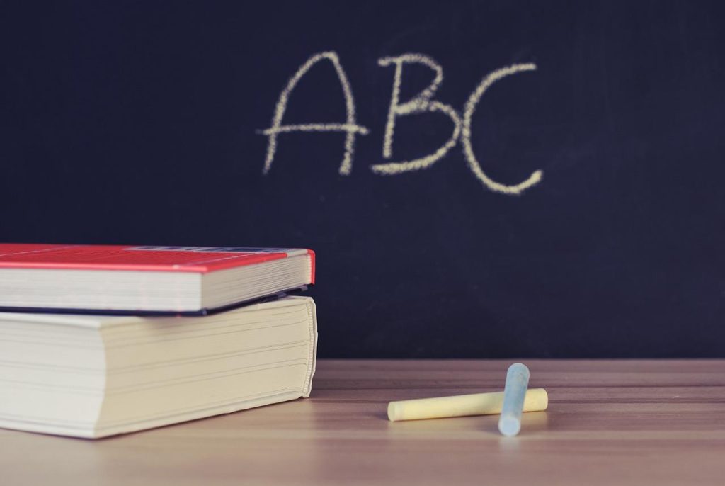 画像：本とチョーク、「ABC」と書かれた黒板