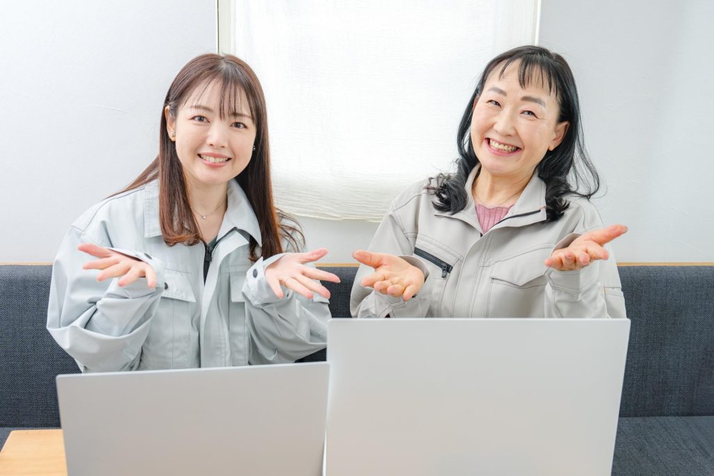 画像：紹介のジェスチャーをする職業女性2人