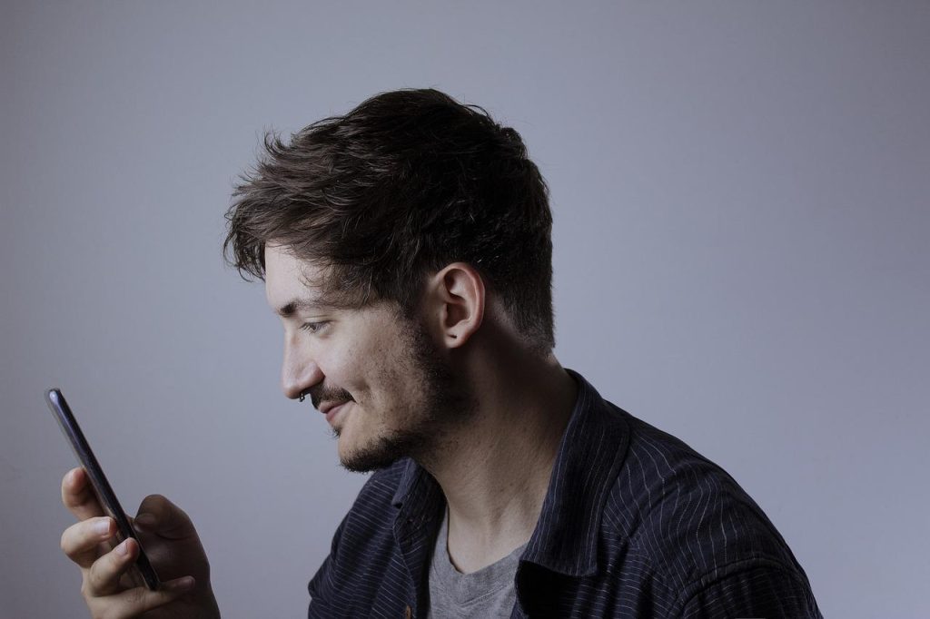 画像：スマートフォンを見る男性